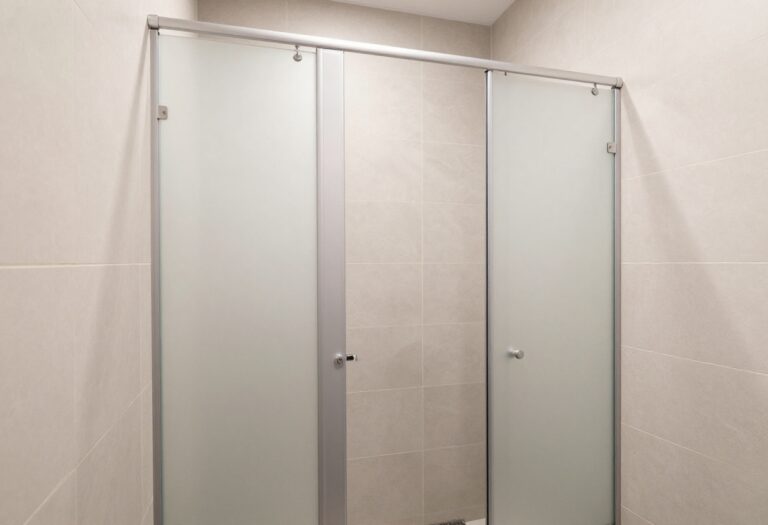 Modern shower stall with elegant tile design, showing a blend of textures and soft lighting in a clean, stylish bathroom.