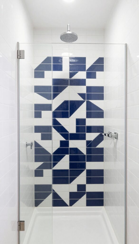 Small shower with bold patterned accent wall, white tiles, rainfall showerhead, clear glass door, bright natural light