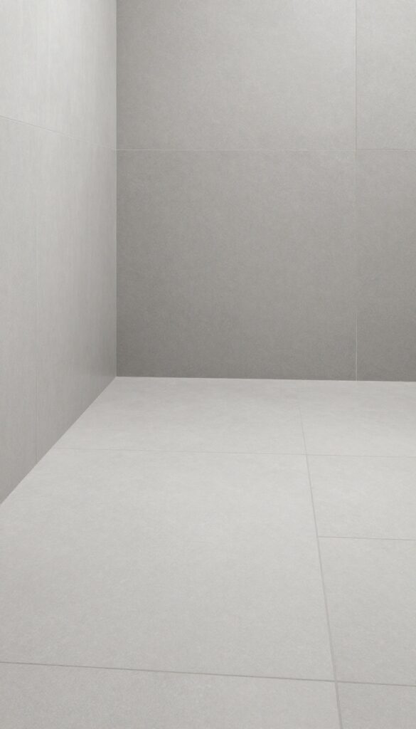 Walk-in shower floor with large-format porcelain tiles in soft gray for a seamless, modern look