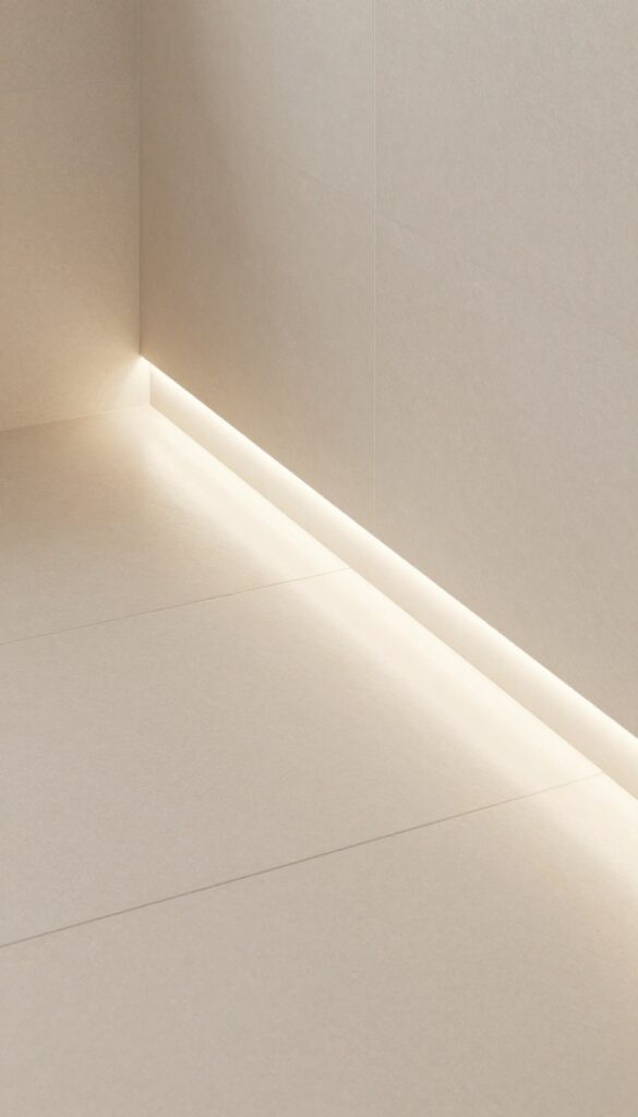 A modern bathroom shower threshold with recessed LED lighting casting a soft warm glow along the edge, highlighting the step and floor in natural light for a clean, spa-like ambiance.