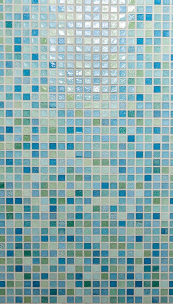 Shower backsplash with mosaic tile magic, textured glass tiles in blue and green, shimmering under natural light