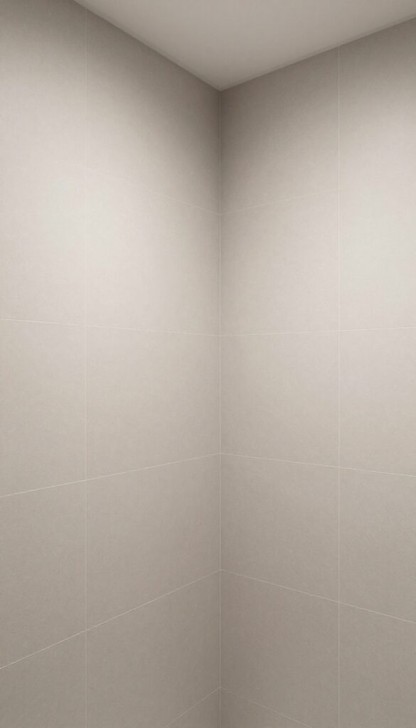 A master bathroom shower with large-format tiles reducing grout lines for a clean, modern look.