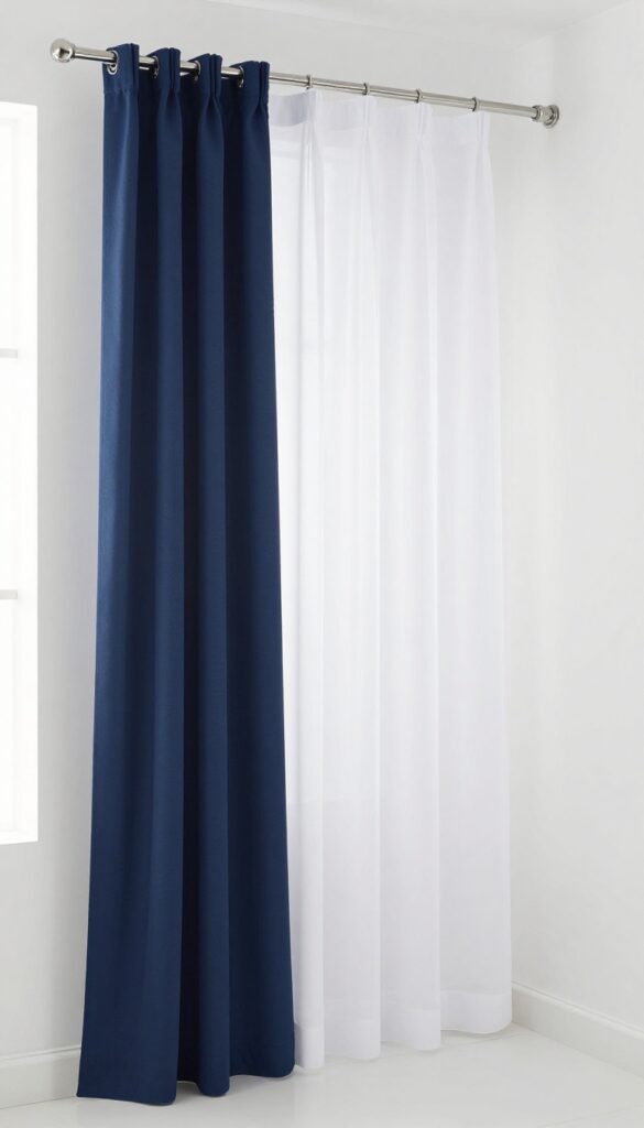Layered sheer white and opaque navy blue tall shower curtains in a bright bathroom, creating a spacious and elegant look with natural light and dual rods.