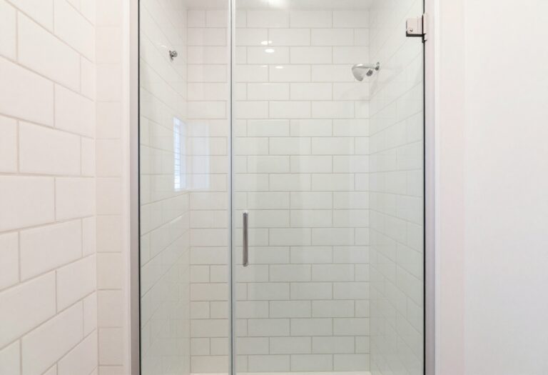 Small bathroom with vertical white subway tile shower and glass door