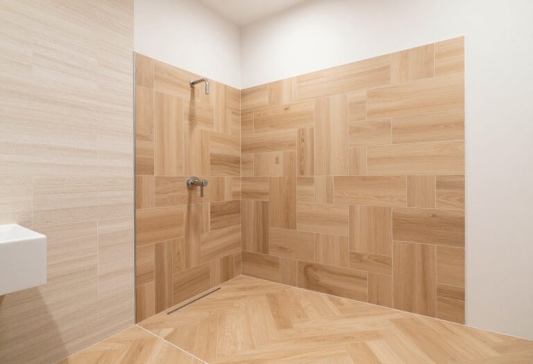Modern bathroom with wood tile shower in herringbone pattern, showcasing warm tones and elegant design.