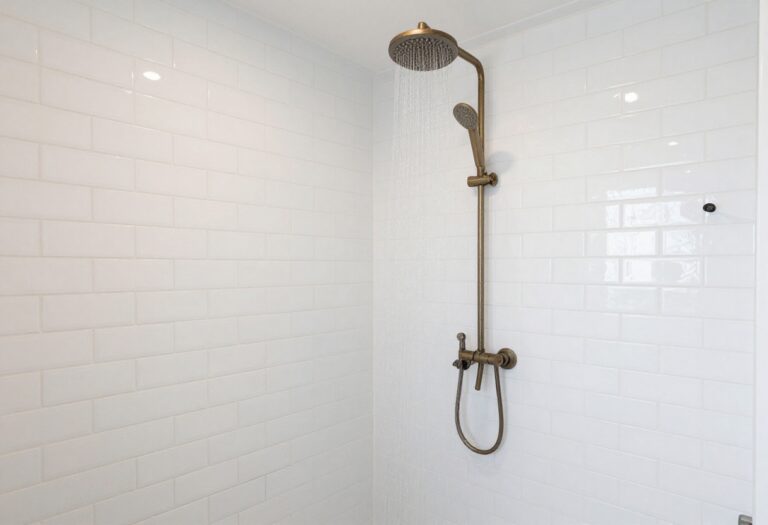 Modern bathroom shower with white subway tiles in herringbone pattern and dark grout, showcasing a stylish and fresh design.