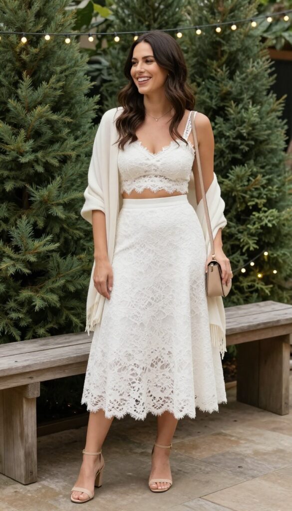 Woman in white lace two-piece set with crop top and skirt at outdoor garden wedding