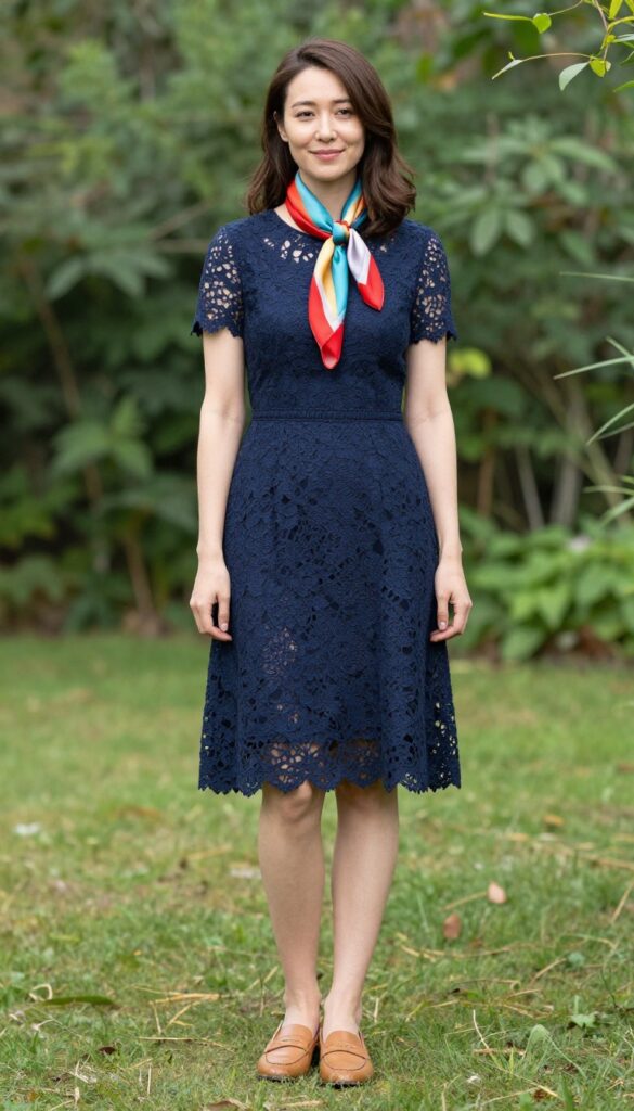 Woman in navy lace dress with silk scarf and loafers in garden