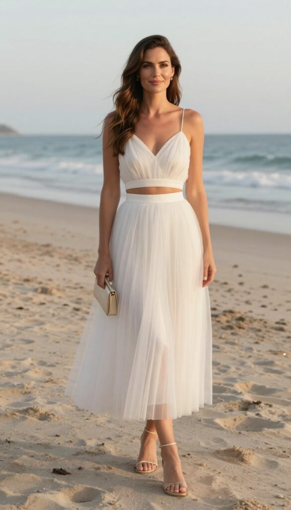 Woman in white tulle crop top and skirt at beach wedding