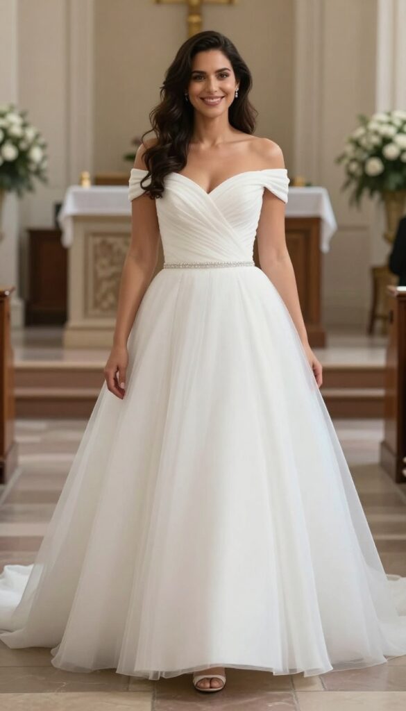 Curvy bride in white ball gown wedding dress with defined waist and full tulle skirt, standing in garden setting.