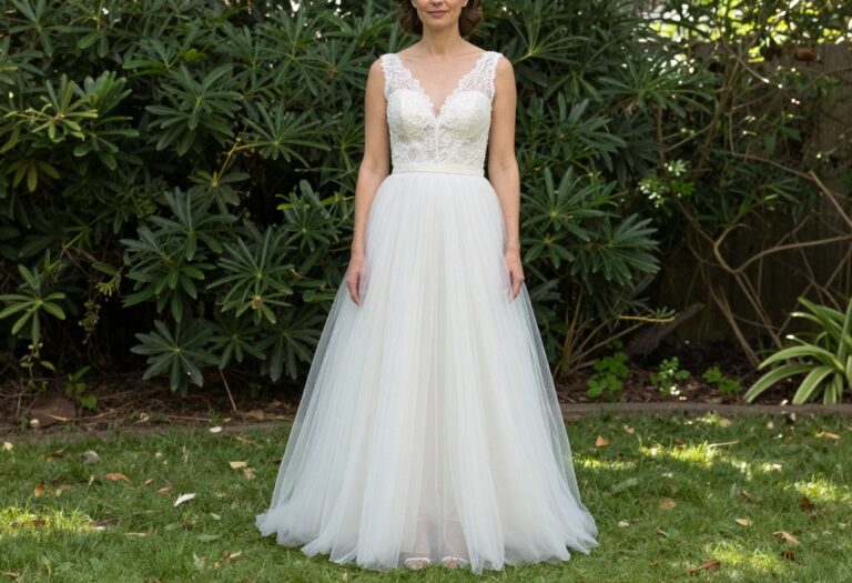 Woman in lace bodice and tulle skirt wedding dress standing in garden