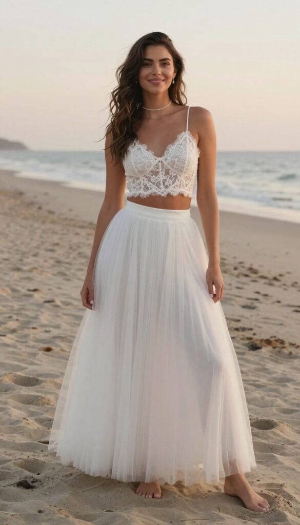 Bride in lace crop top and tulle skirt on beach at sunset, relaxed soft glam wedding outfit