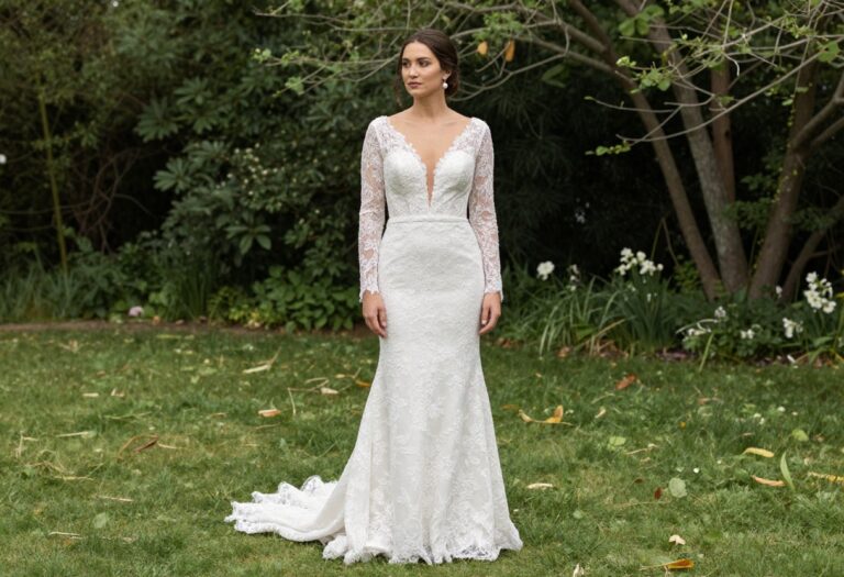 Woman in mermaid wedding dress with long lace sleeves standing in garden