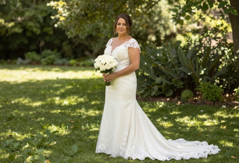 Bride in dramatic lace wedding dress with train in garden