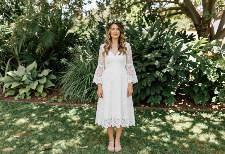 Relaxed bride in white lace A-line dress with bell sleeves and flower crown in garden