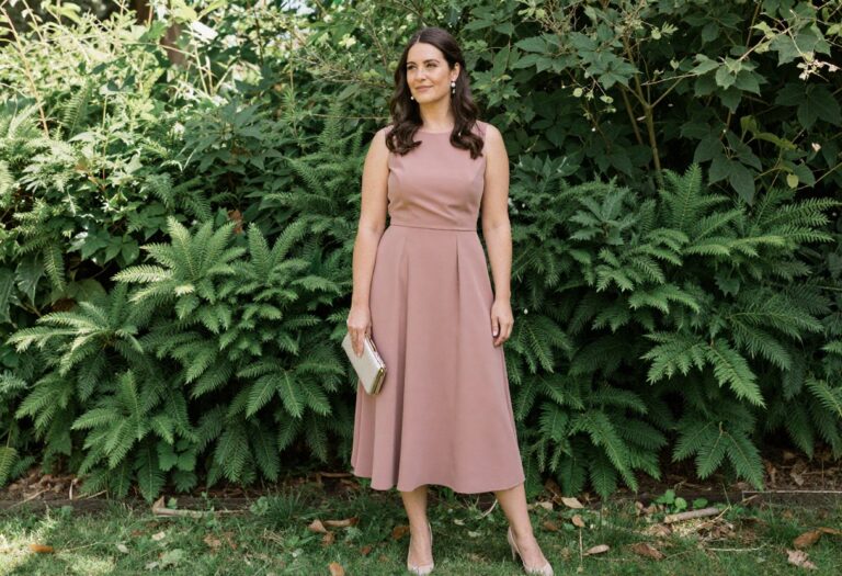 Woman in dusty rose bridesmaid dress with pearl accessories in garden