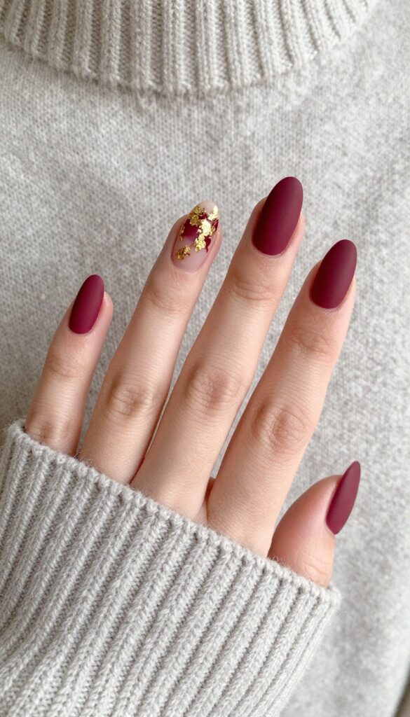 Matte burgundy French tip nails with gold foil flakes