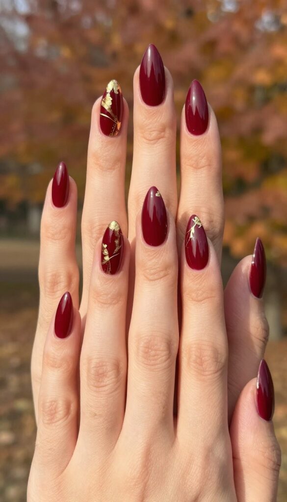 Burgundy stiletto nails with gold foil accents