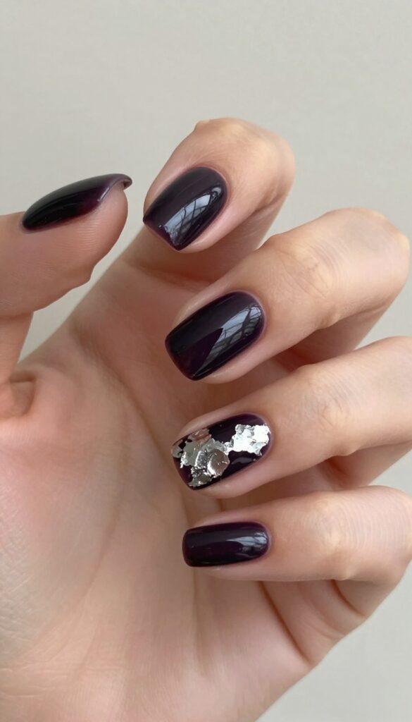 Squoval nails with deep plum polish and silver foil accent nail