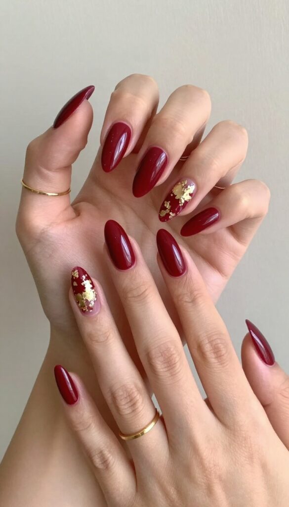 Cranberry stiletto nails with gold foil accents