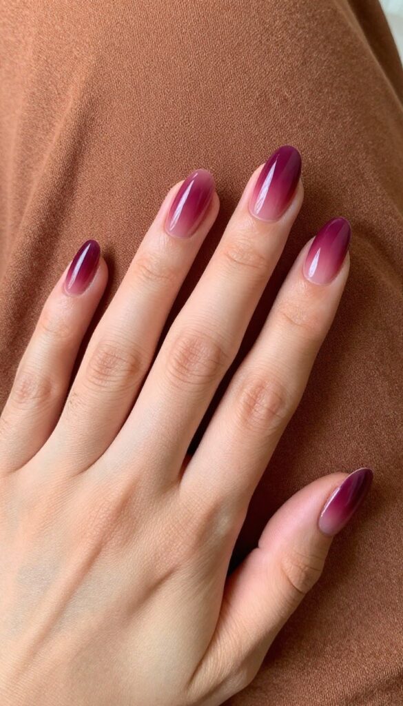 Short almond nails with a plum to sheer wine ombre gradient, glossy finish