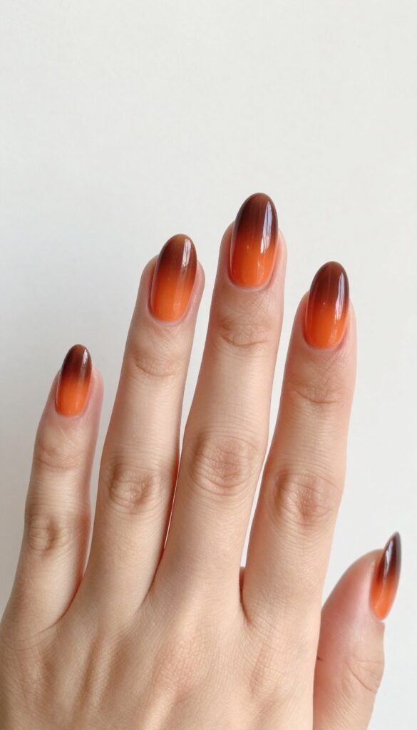 Almond nails with ombre gradient from burnt orange to cocoa brown