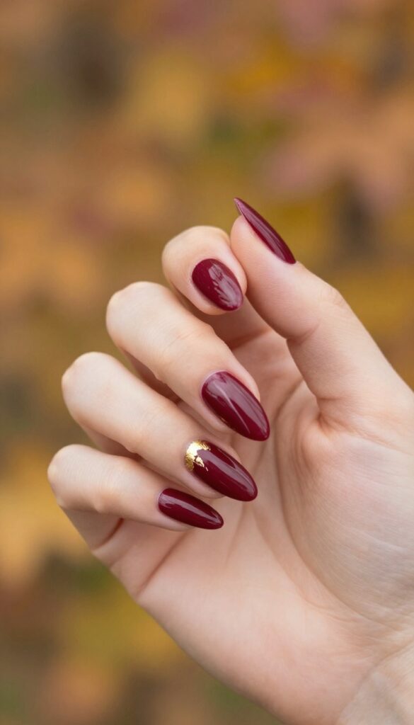 Burgundy stiletto nails with gold foil accents
