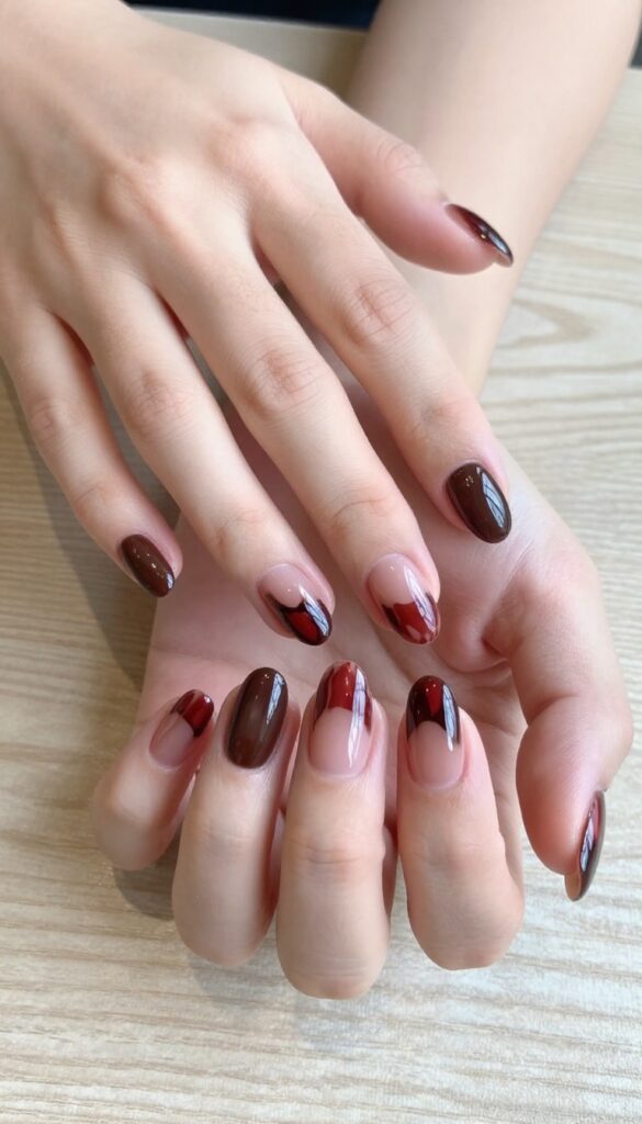 Chocolate cherry swirl gel nails on almond-shaped nails with glossy finish
