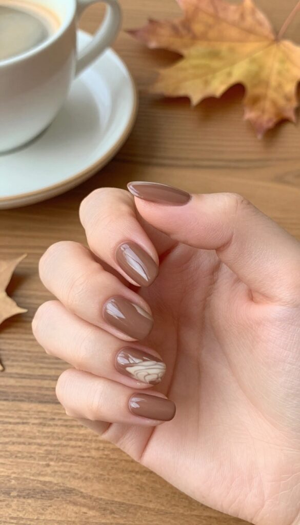 Mocha swirl almond nails with matte base and glossy cream swirls on medium-length nails