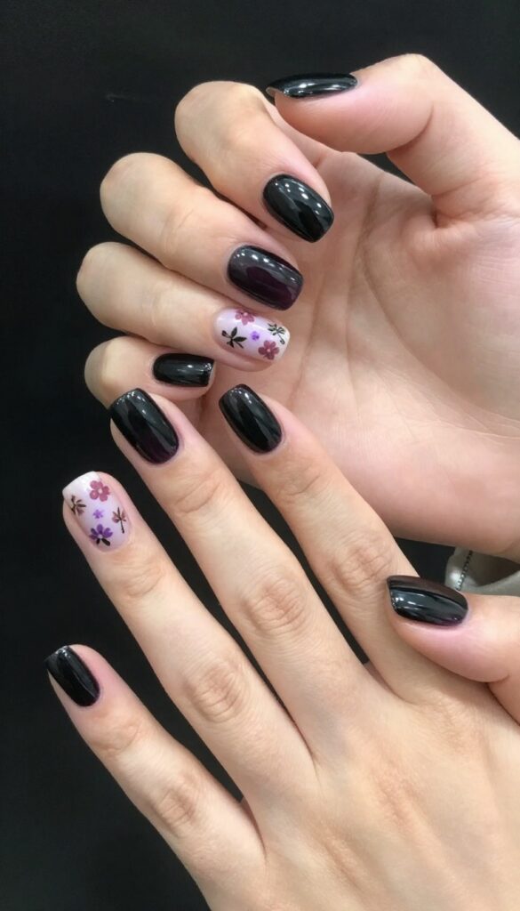 Midnight bloom nails with dark aubergine base and muted floral accents on almond shape