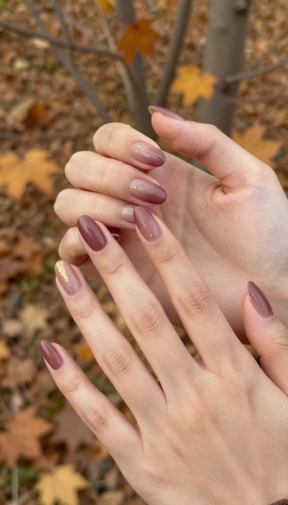 Matte plum nails with gold speckles, almond shape, autumn manicure
