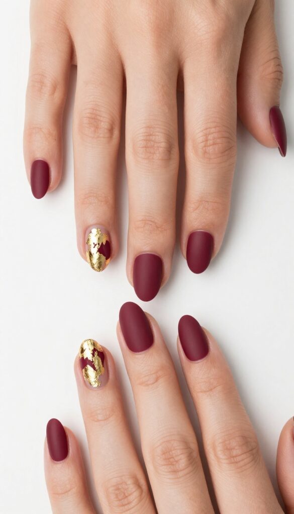 Matte burgundy nails with gold foil accents