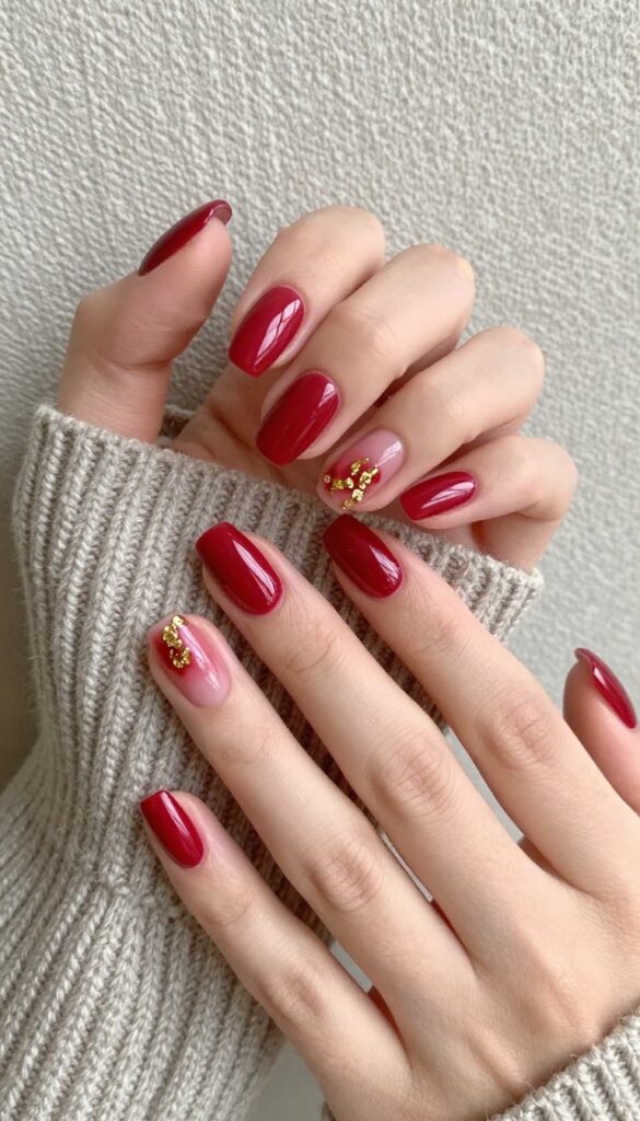 Short almond nails in cranberry red with gold foil accents