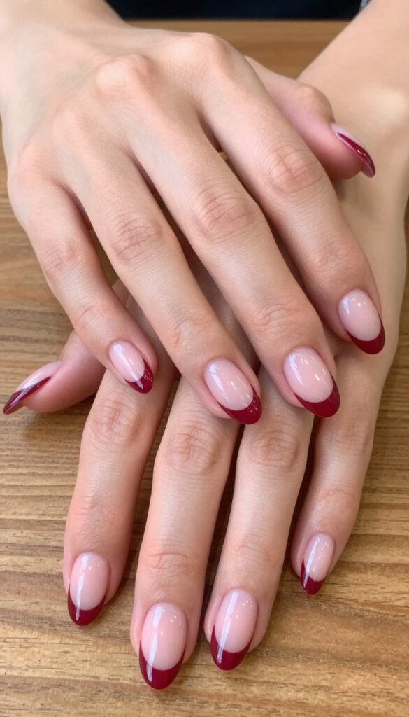 Cranberry French tips with glossy finish on almond-shaped nails