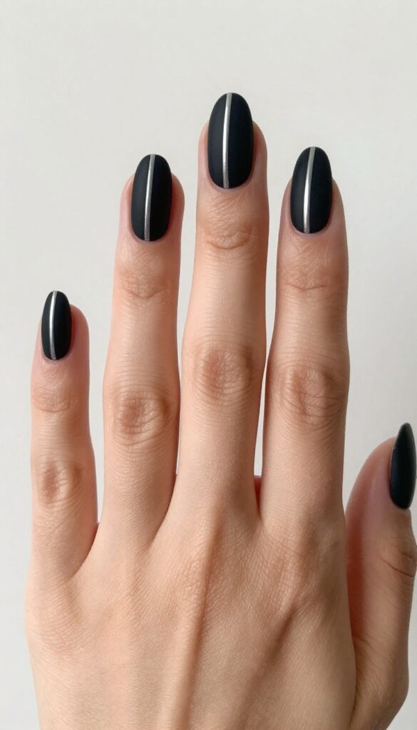 Matte black nails with a single silver stripe down the center, almond shape, medium length, velvety finish.
