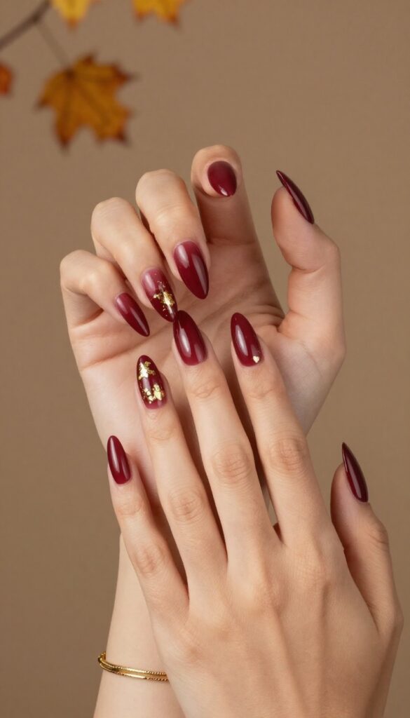 Burgundy stiletto nails with gold foil accents