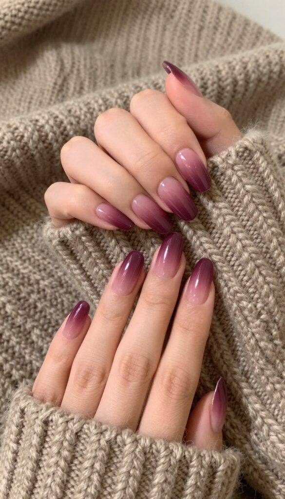 Plum velvet ombré nails on almond-shaped nails with a seamless gradient from deep plum to soft mauve, high-shine finish, and cozy fall setting.