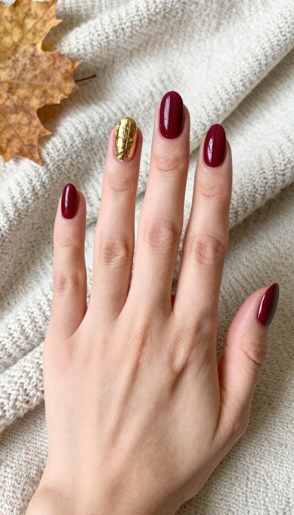 Classic burgundy nails with gold foil stripe accent for fall