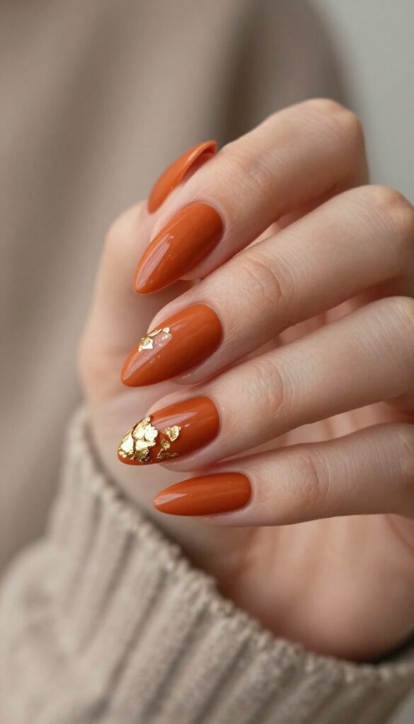 Burnt orange stiletto nails with gold foil accents
