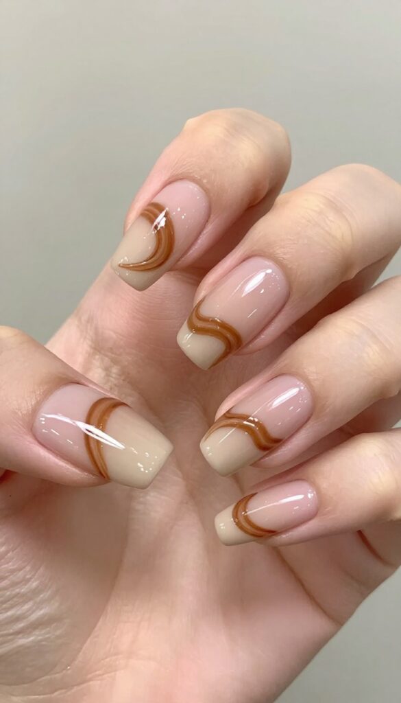 Cinnamon swirl almond nails with nude base and warm brown swirls