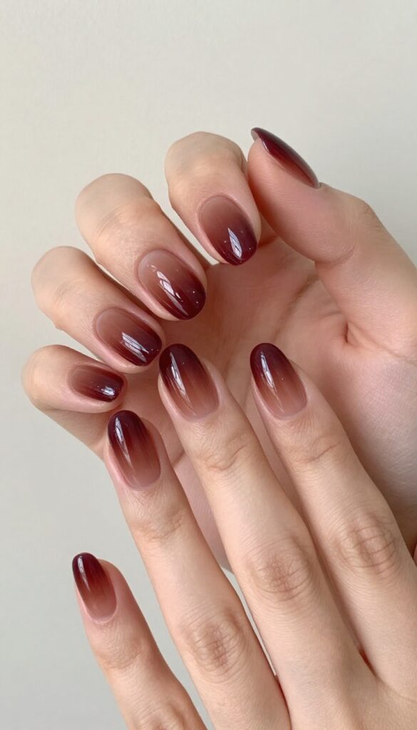 Chocolate cherry dip ombre nails with glossy finish on rounded almond shape