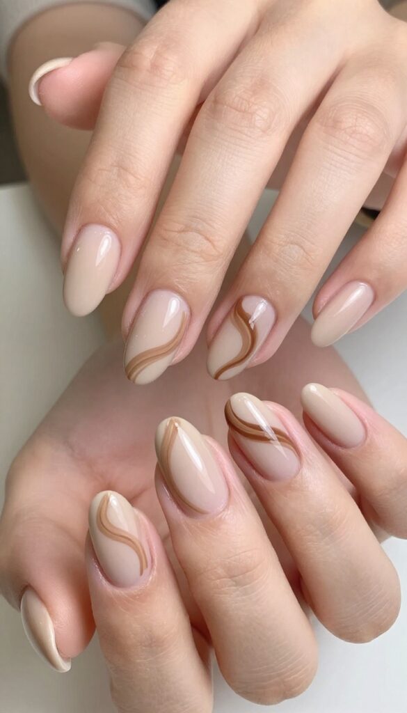 Short almond nails with mocha swirl nail art, matte beige base and glossy brown swirls