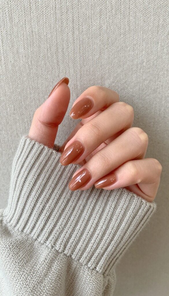 Glazed cinnamon brown almond nails with glossy shimmer finish