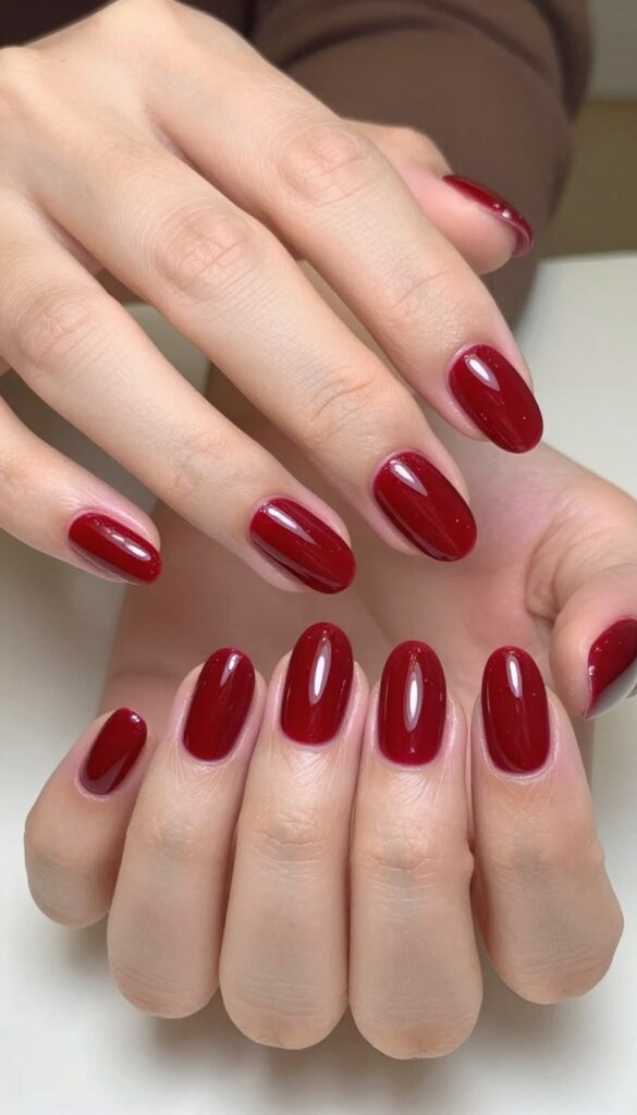 Glossy cherry cola red almond nails with high-shine finish