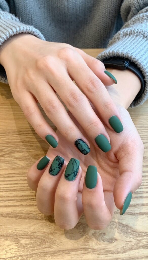 Mossy marble swirl nails in forest green with black veins, matte finish, short almond shape