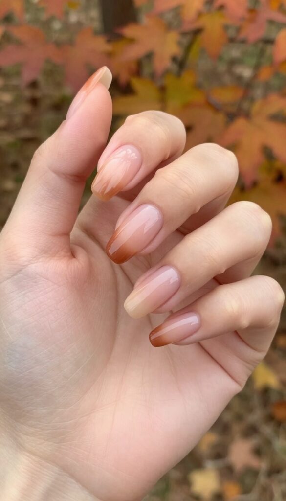 Burnt sienna to pale peach ombre nails on almond shape with glossy finish