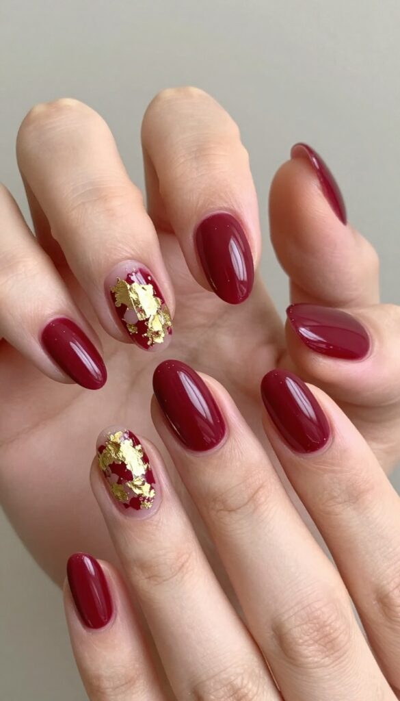 Cranberry stiletto nails with gold foil accents