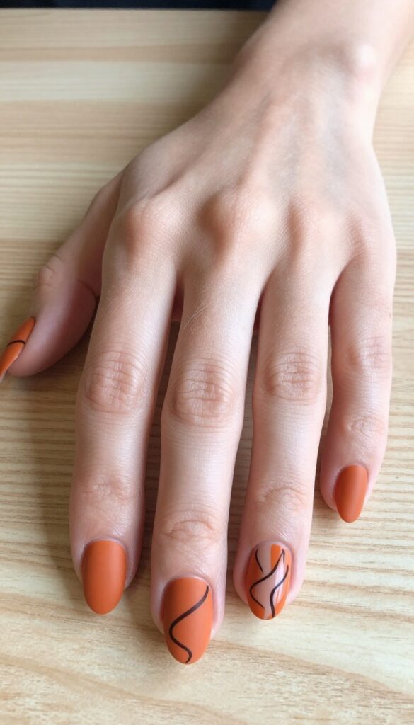 Abstract brown swirls on matte burnt orange nails