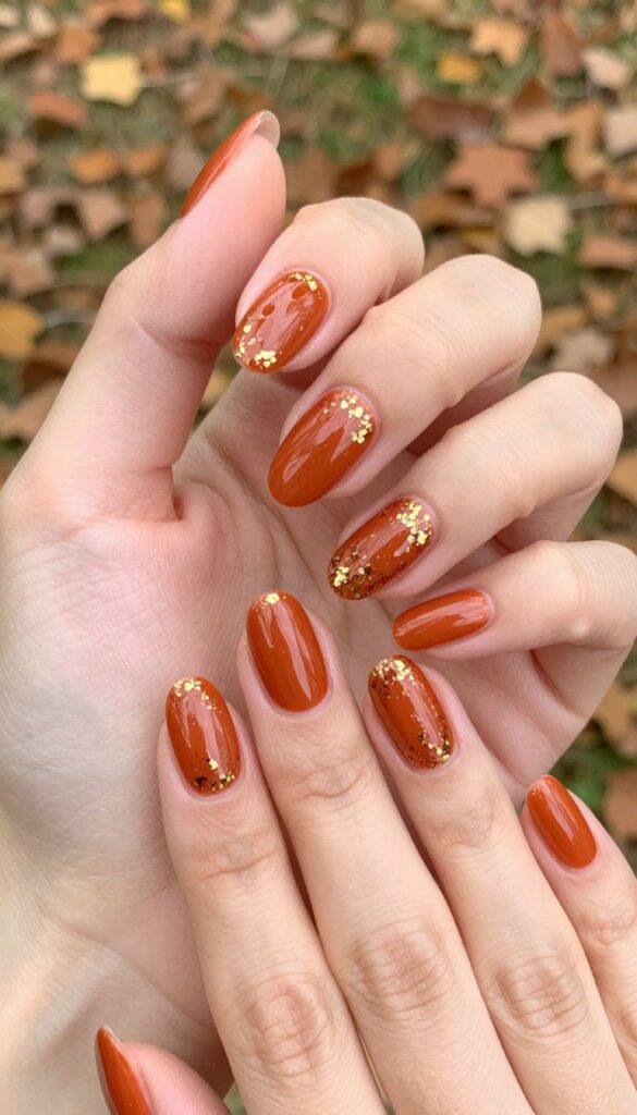Burnt orange almond nails with gold flakes