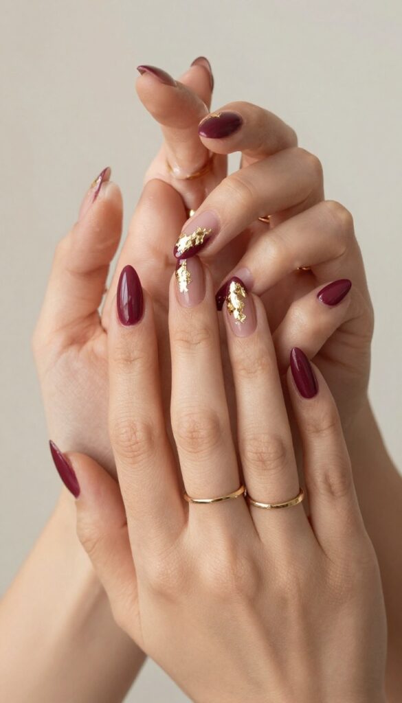 Burgundy stiletto nails with gold foil accents